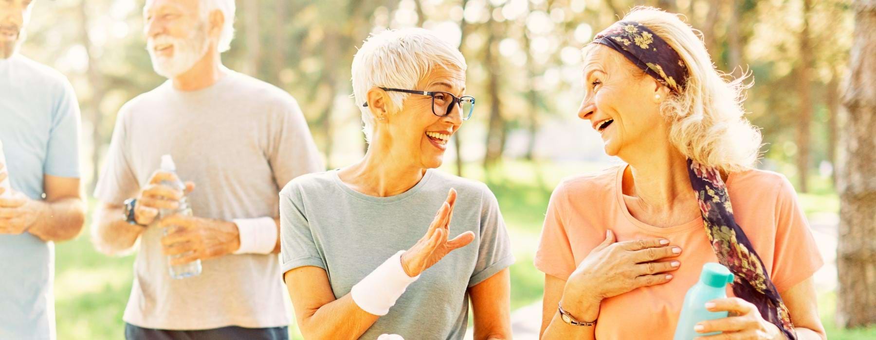 Residents smiling outside Northstar Georgetown 55+ senior living apartments in Georgetown, TX, featuring natural lighting.