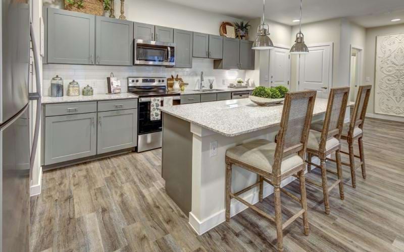 Model kitchen at Northstar Georgetown 55 plus community, featuring wood grain flooring and a kitchen island.
